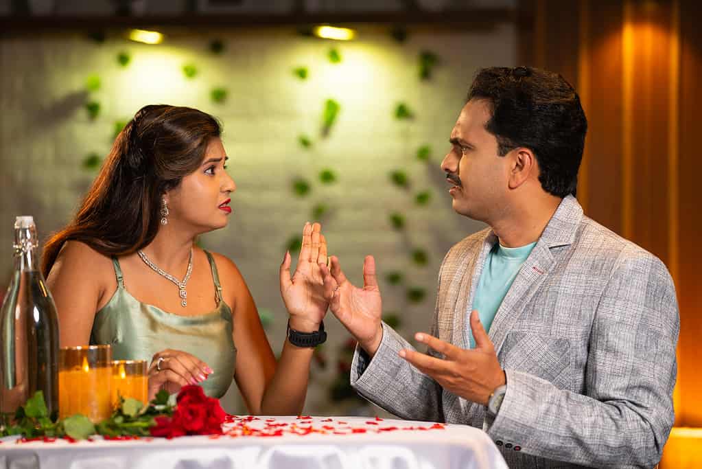 Indian couples arguing or fighting during dating or candlelight dinner arrangements - concept of relationship problems, love rejection and misunderstanding