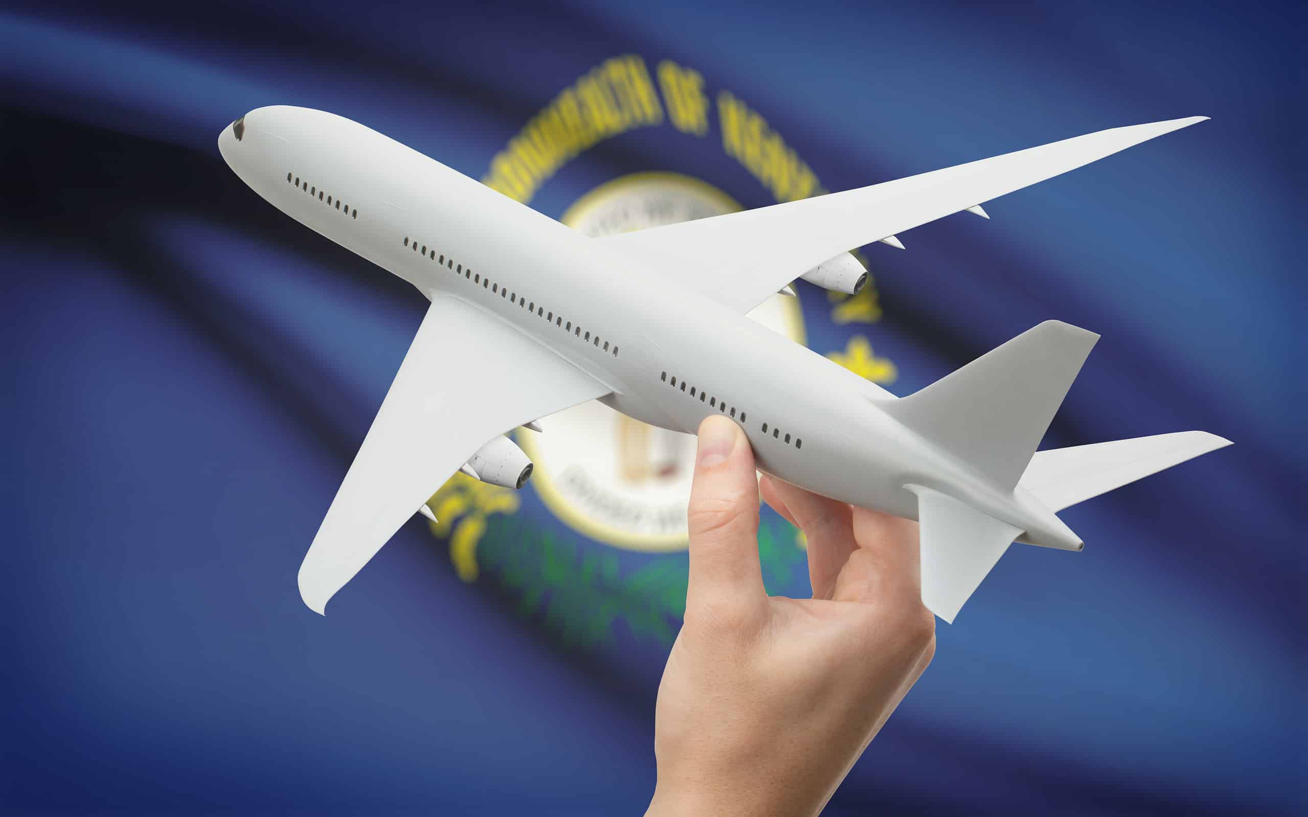 Airplane in hand with US state flag on background - Kentucky