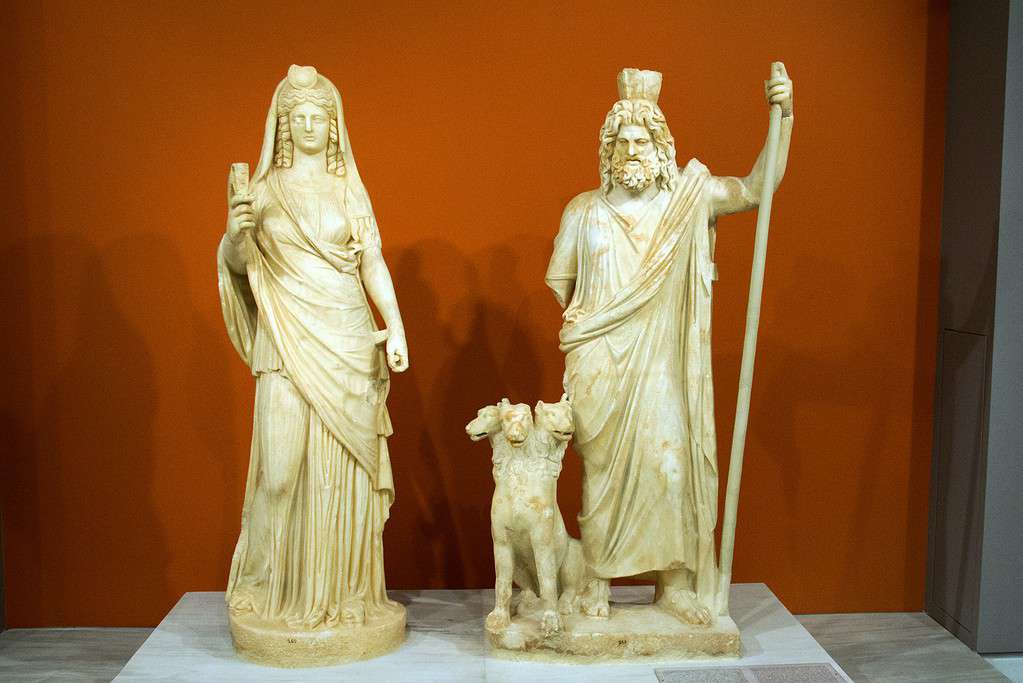 English: Persephone as Isis and Pluto as Sarapis (with Cerberus). Marble, 2nd century AD. Finding from the Temple of the Egyptian Gods in Gortys. Archaeological museum of Heraklion.
