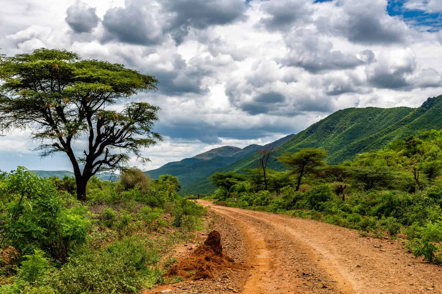 Remote rural area near Siracho Escarpment, Baringo County, Kenya looking across the Great Rift Valley. The rough dirt road is rocky and off the beaten track. Storm brewing. Natural landscape scenery.