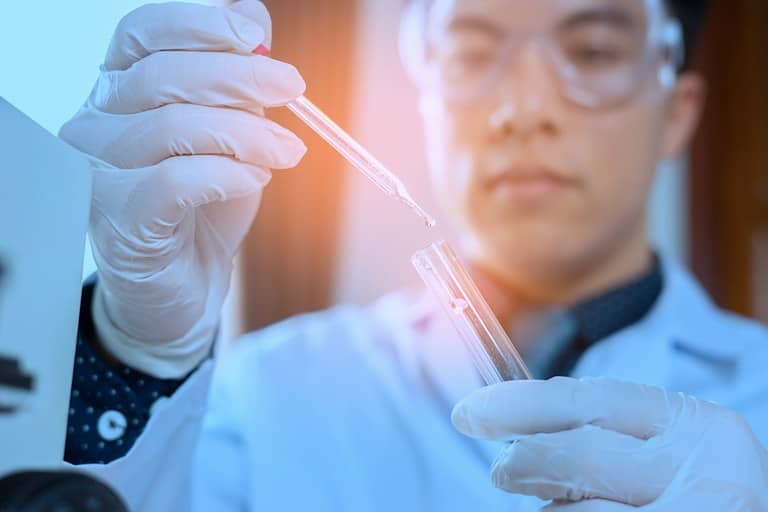 Laboratory Medical scientists working at lab with test tubes researcher performs liquid, doctor supervisor looking at the microscope slide in the forensic,concept with Asian man chemistry