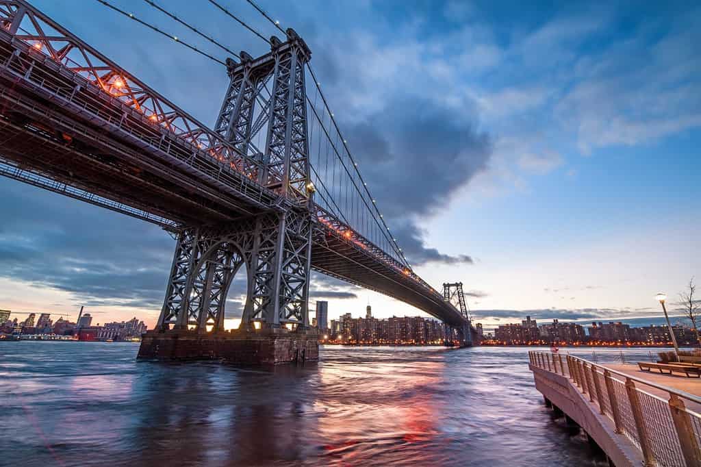The Williamsburg Bridge is a suspension bridge across the East River at night in New York City , USA