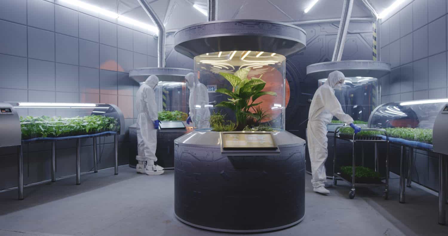 Full shot of scientists in hazmat suits checking plant incubators on a Mars base