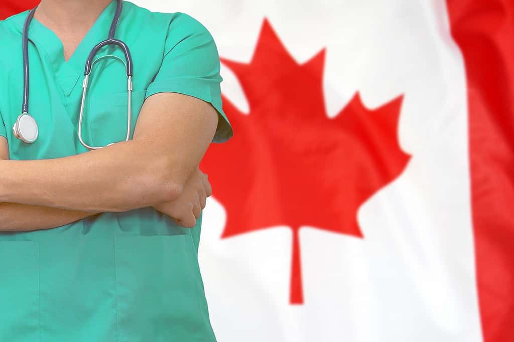 Male surgeon or doctor with stethoscope on the background of the Canada flag. Health care and medical concept. Surgery concept in Canada.