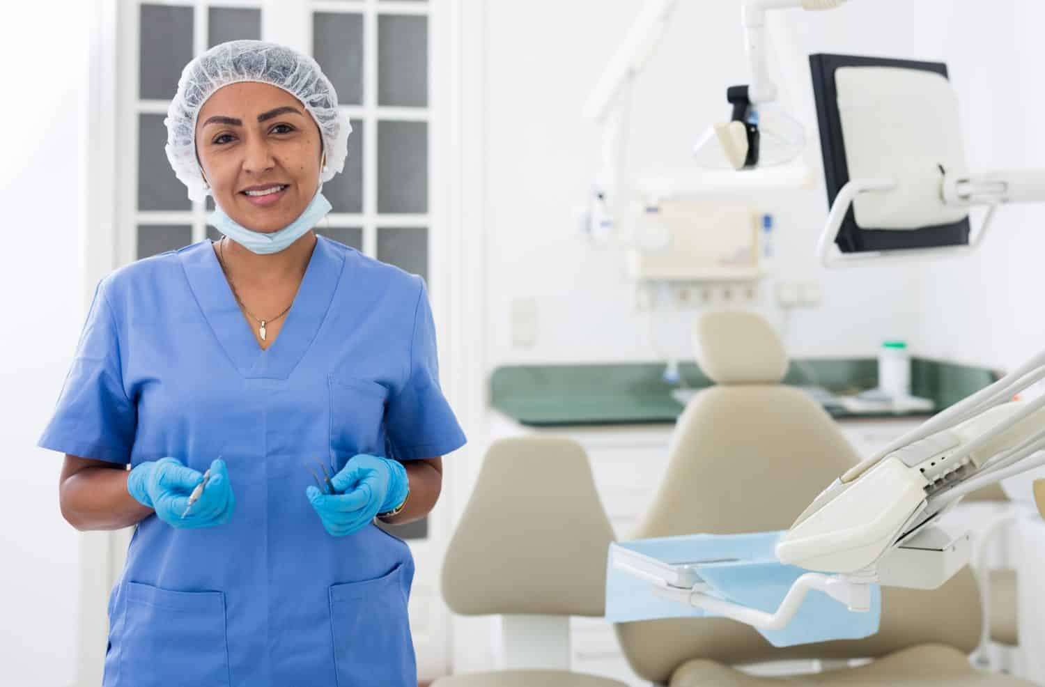 Portrait of female dentist in medical center standing near the chair
