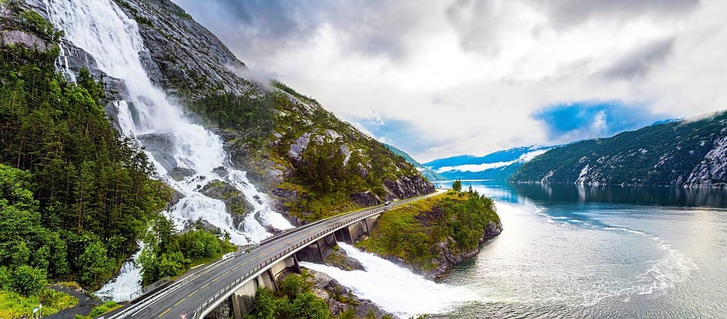 Langfossen cascade waterfall on the Vaule river. Passes through the highway. Summer cold and rainy day. Western Norway. The photo was taken with a drone.