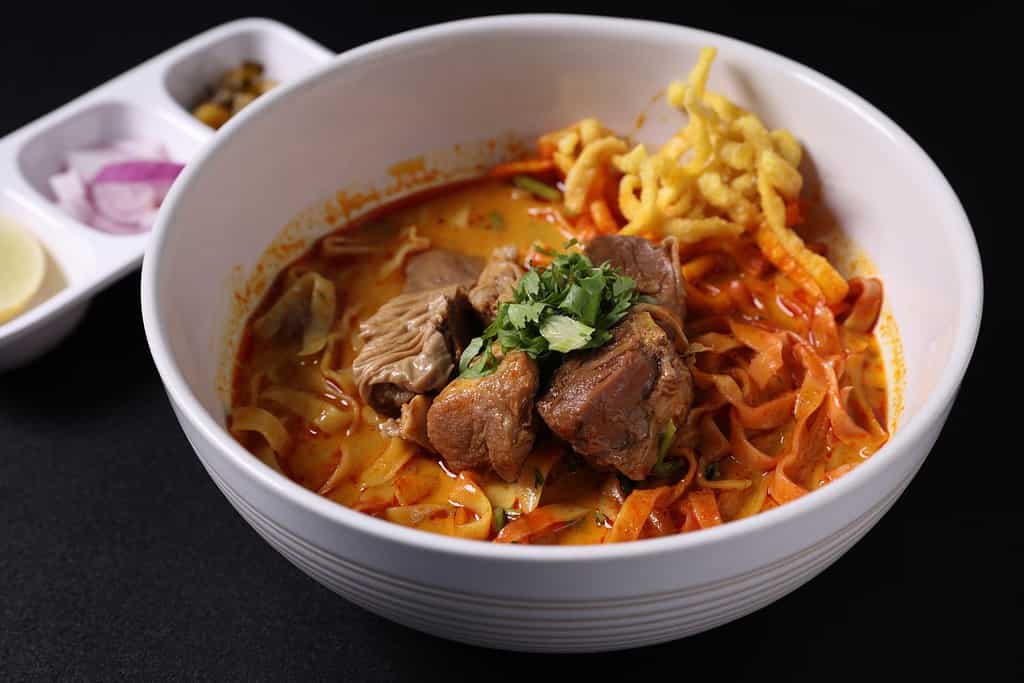 Khao Soi Thai Curry soup isolated in black background