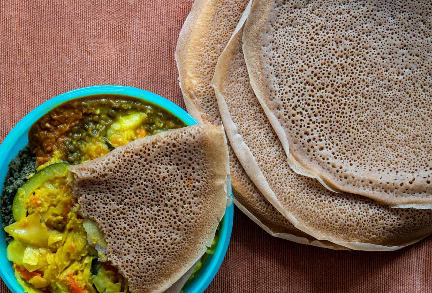 Flat lay view of Injera with lentils and vegetables, Injera is a sour fermented flatbread popular in Ethiopia and Eritrea