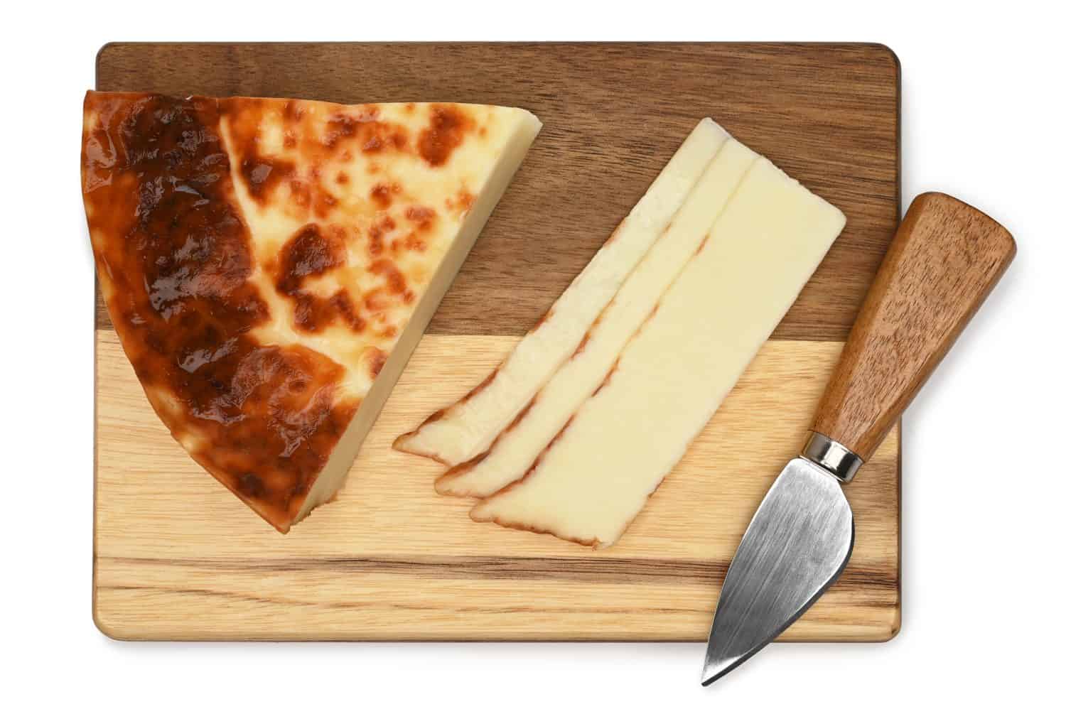 Leipajuusto, Finnish squeaky cheese (bread cheese)  with cheese knife on a wooden board on white background