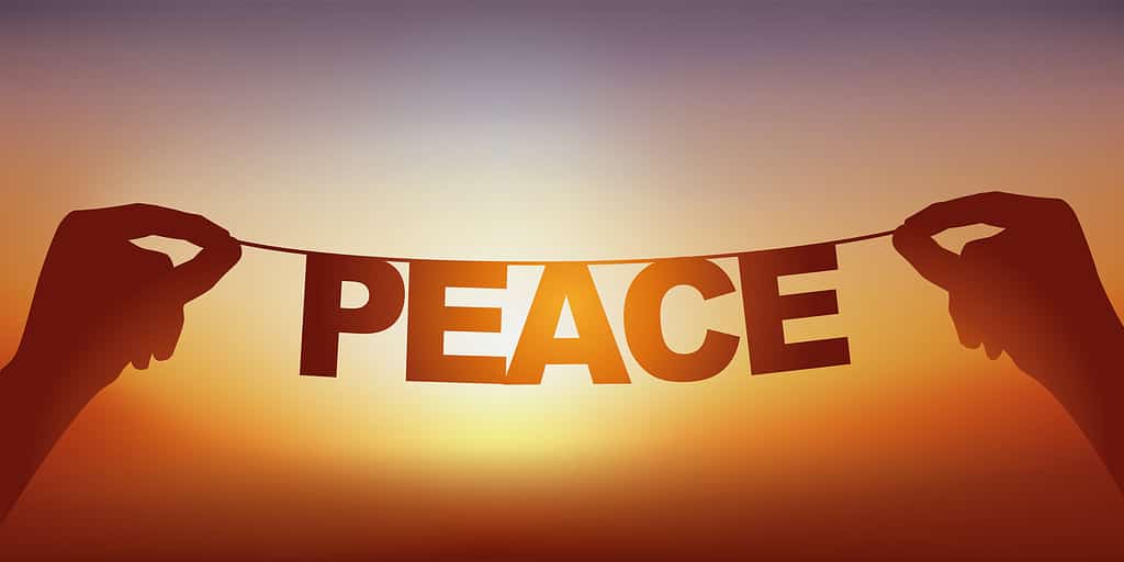 A garland featuring the word peace in the setting sun.