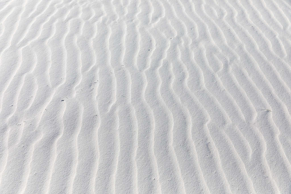 Close up of patterns the wind has blown into white sand