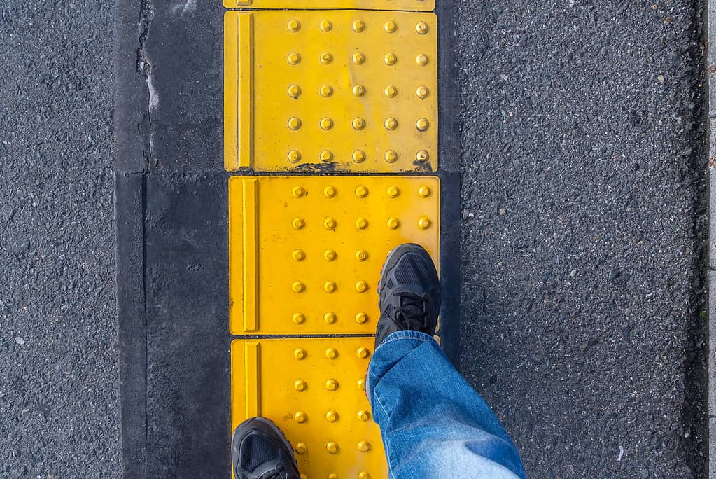 Straight Braille block for the visually impaired on pedestrian walkway. Tactile ground surface indicators for blind and visually impaired.