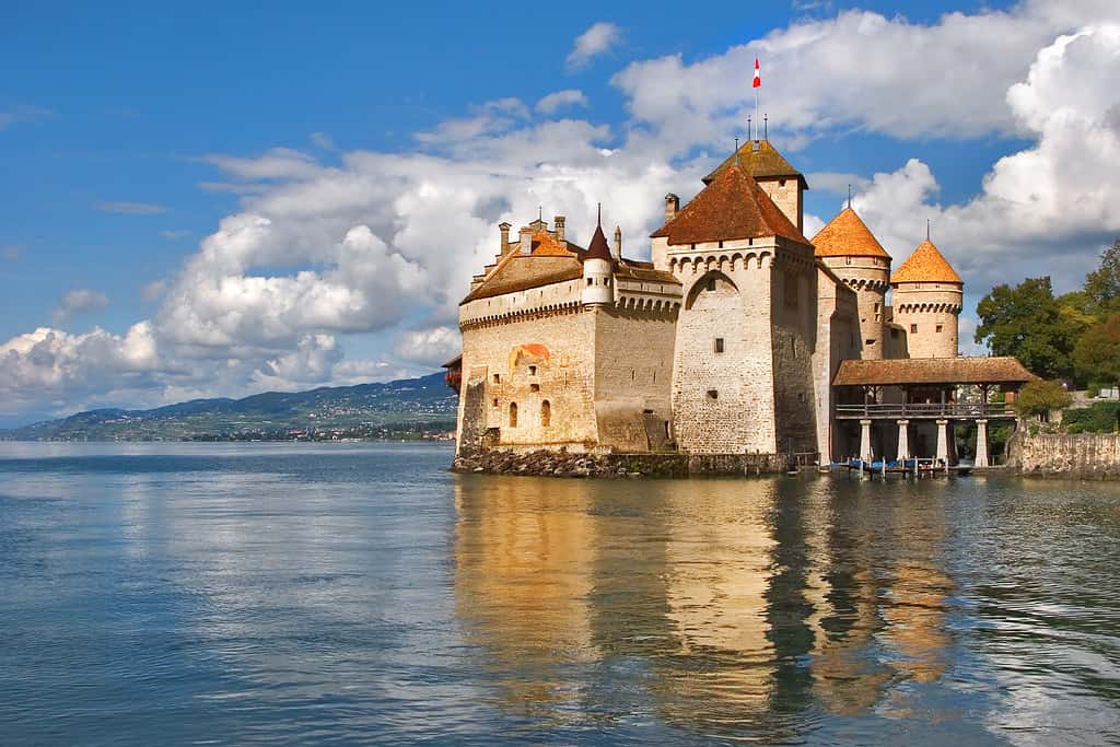 White clouds above mountains and Chillon Castle