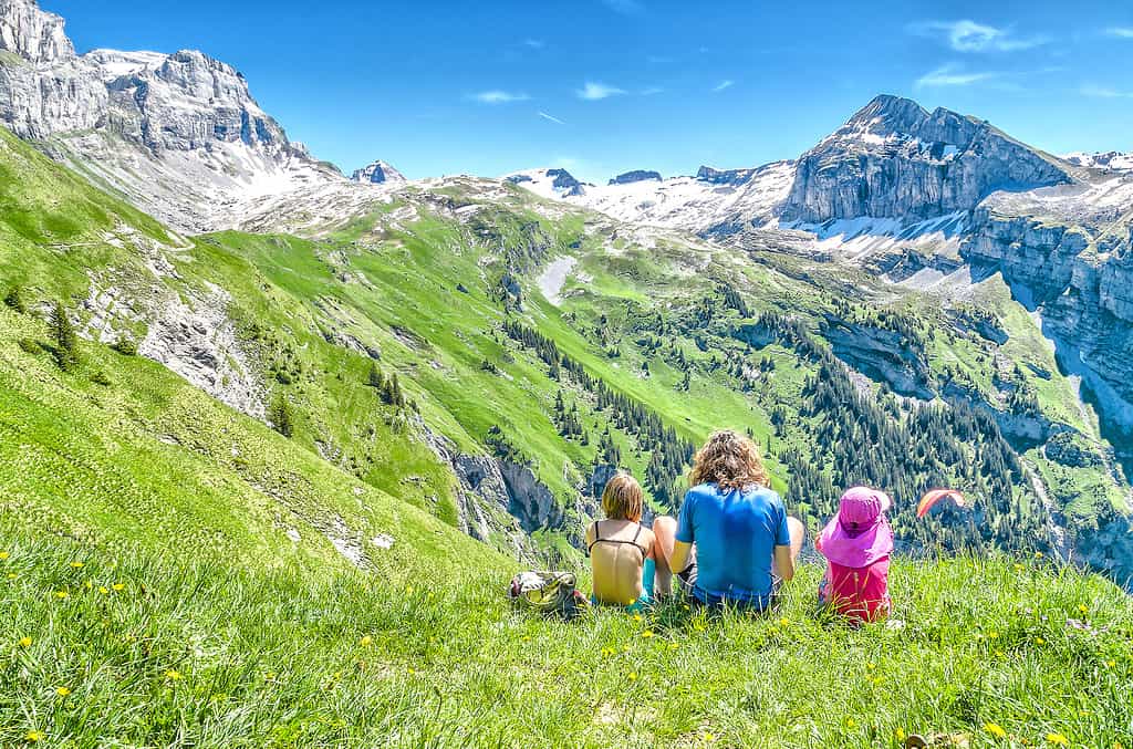young people sitting on a meadow surrounded by Swiss nature