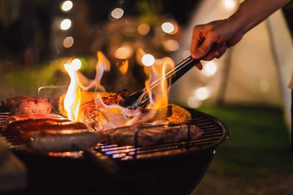 Family making barbecue in dinner party camping at night