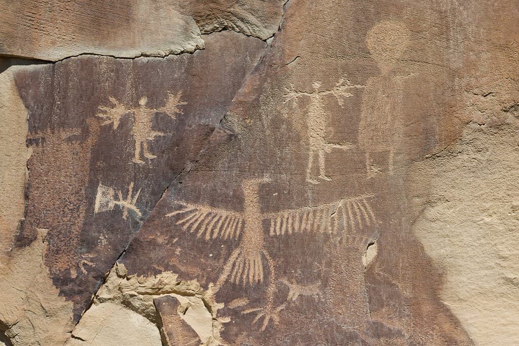 Strange shapes and figures that have been carved into the ancient sandstone rocks along with more modern graffiti at Legend Rock State Petroglyph Site, Wyoming.