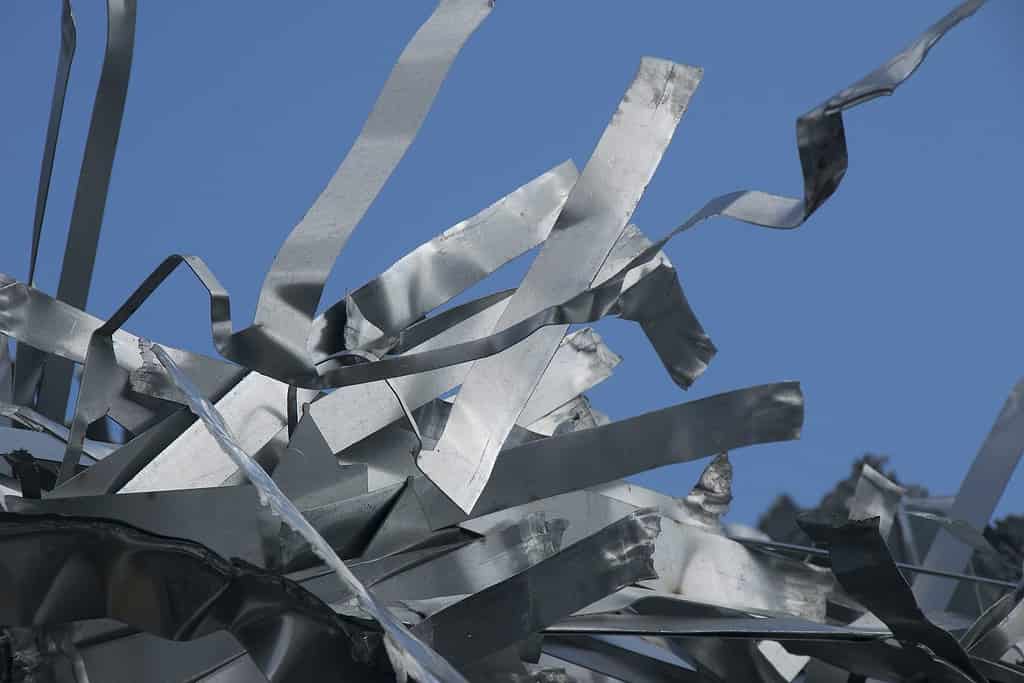 pieces of iron parts from scrapped cars and other metal after crushing and separation from other metals as a background