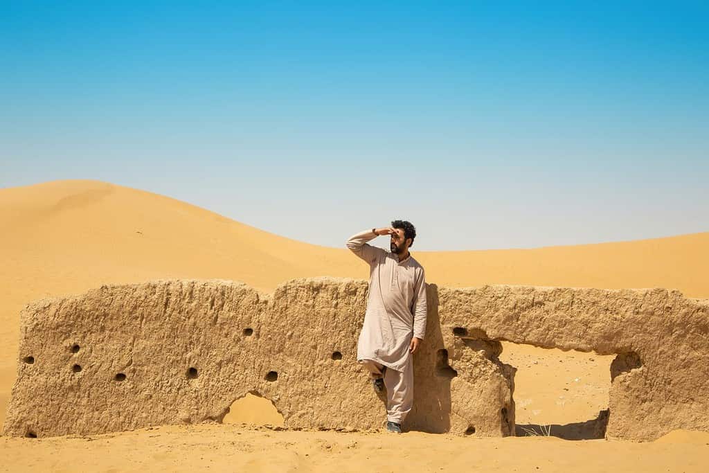 Young adult Pakistani male looking away in a desert in the outskirts of Quetta, Pakistan