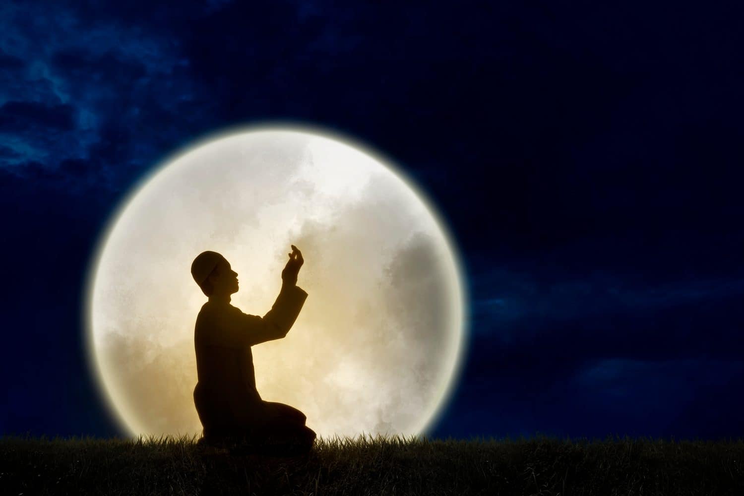 Double exposure image of silhouette muslim man praying with a huge full moonlight background