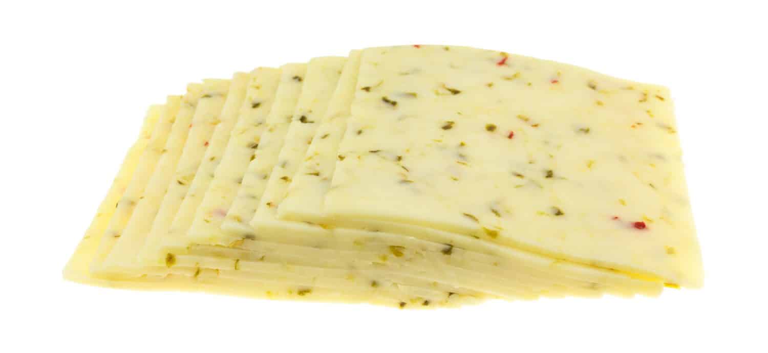 Side view of several slices of pepper jack cheese isolated on a white background.