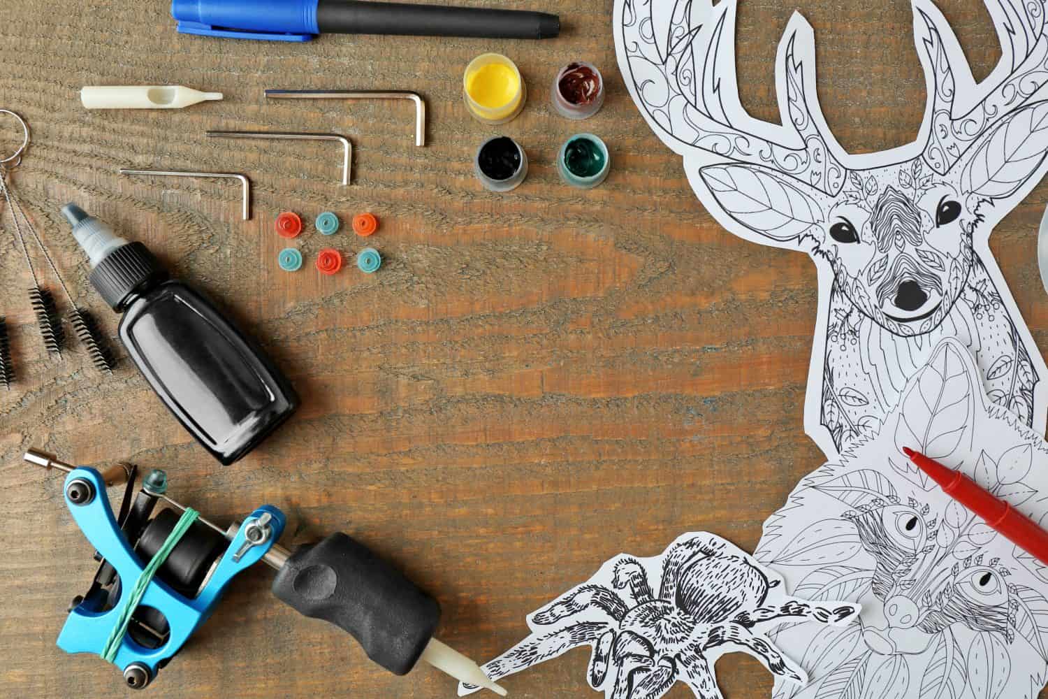 Tattoo machine and supplies on wooden background
