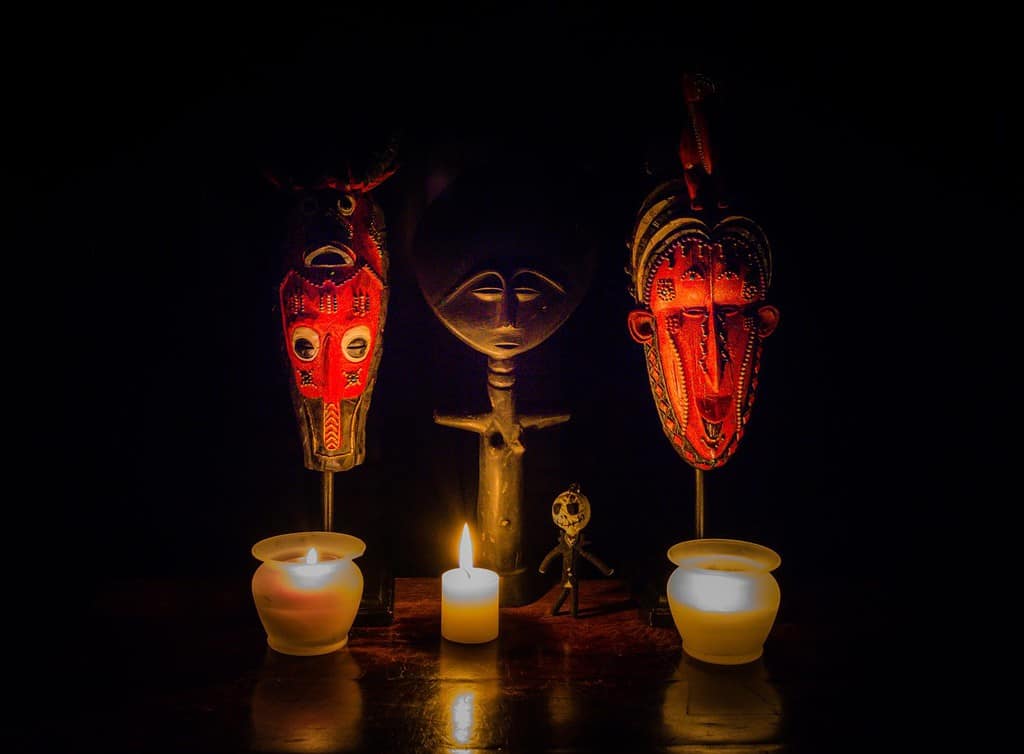 Voodoo Ritual - a stylized image depicting a voodoo ritual. African masks, a fertility goddess, a voodoo doll and candles make for a striking image.