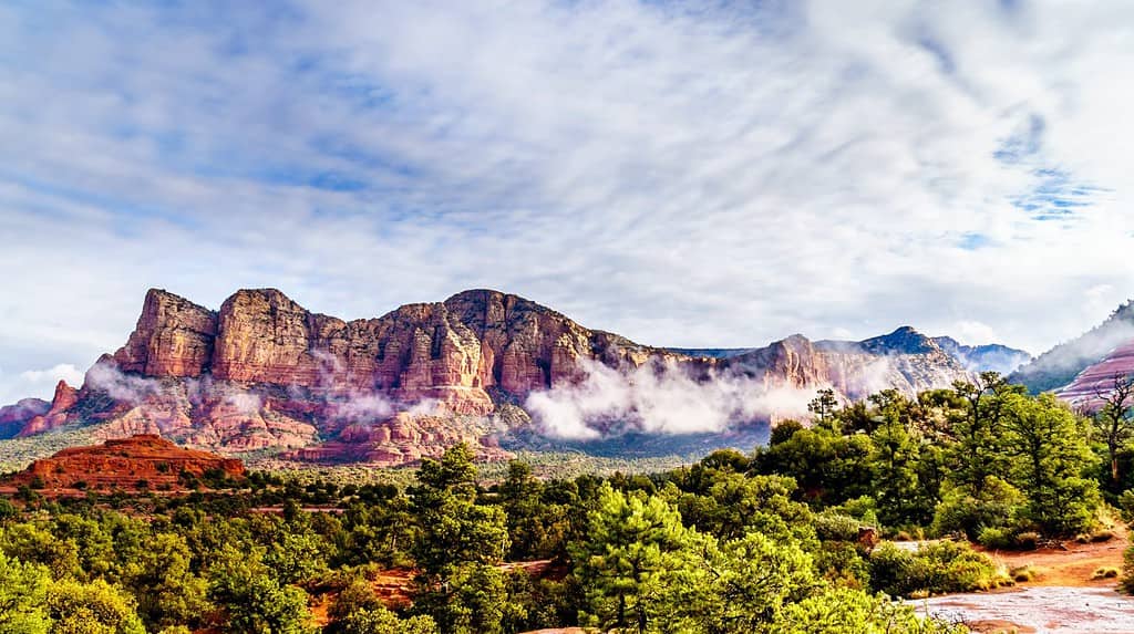 Clouds hanging around Lee Mountain, Munds Mountain and other red rock mountains surrounding the town of Sedona in northern Arizona in Coconino National Forest, United States of America