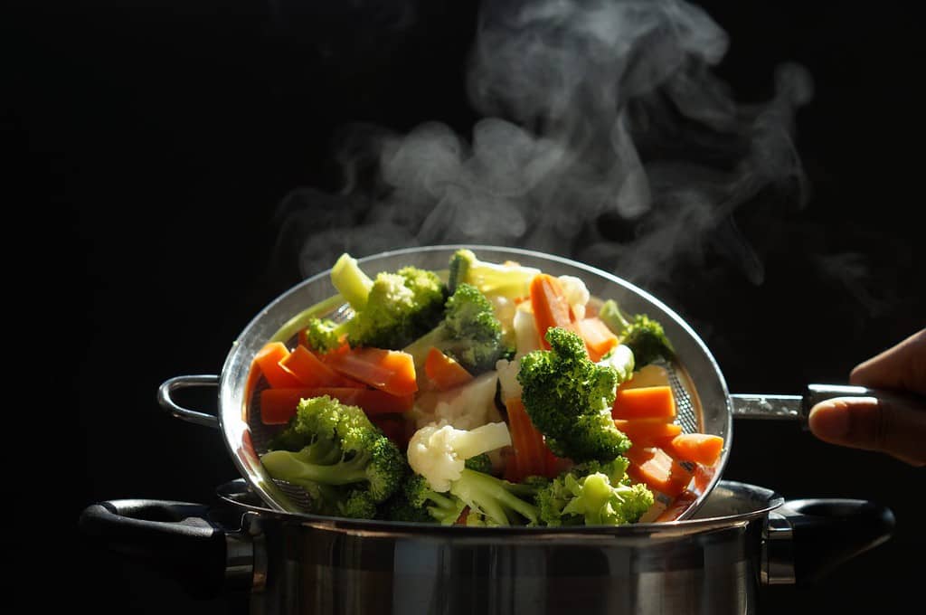 steaming of hot boiled vegetables. Basket of vegetables that just boiled from hot water with steam selective focus, soft focus. hot food, diet and healthy concept.