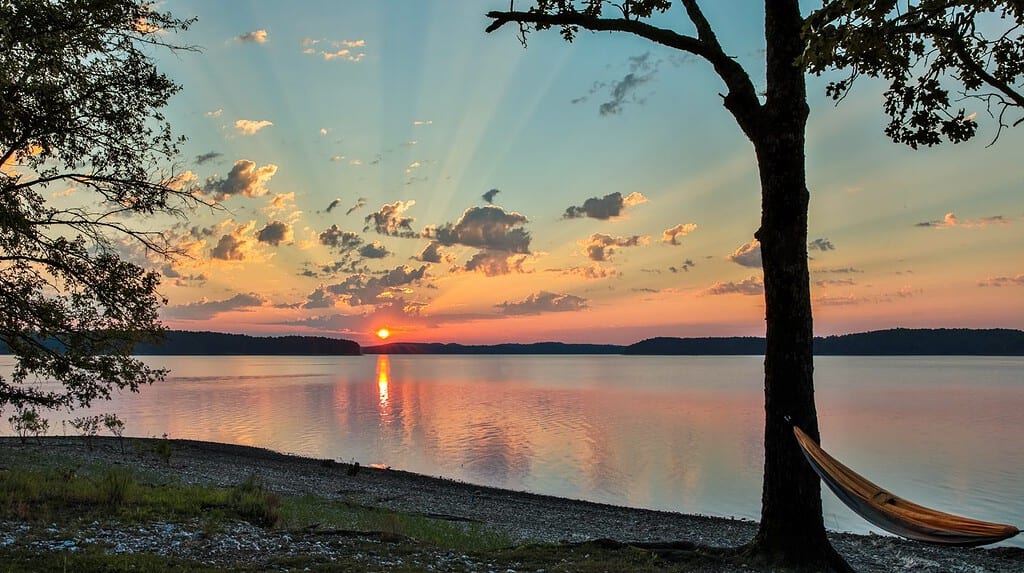 Hammock on rock beach looking at a beautiful sunrise over lake Ouachita