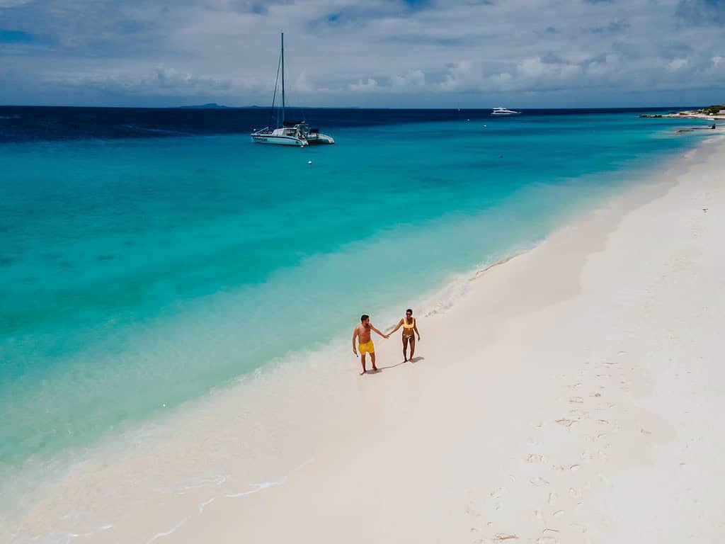 Small Curacao Island famous for day trips and snorkeling tours on white beaches blue clear ocean, Curacao Island in the Caribbean sea. a couple of men and woman on the beach during a vacation holiday