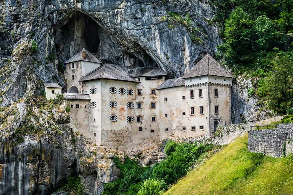 Dramatic scenery of medieval cliff top Predjama castle and caves, Slovenia