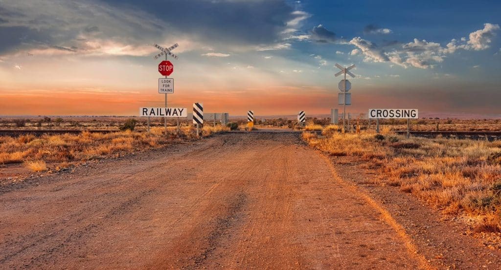 Stop sign at a railway crossing in the outback of South Australia. sign saying look out for trains. Sunrise