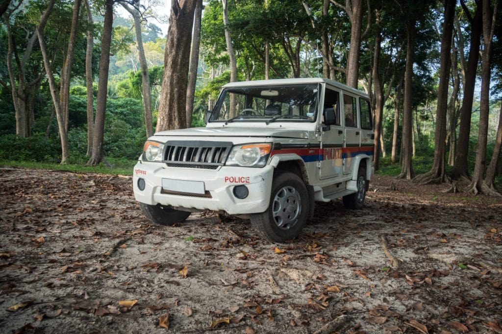 Car SUV on forest road. White car tourist police in the woods of Havelock island, Andaman and Nicobar Islands, India
