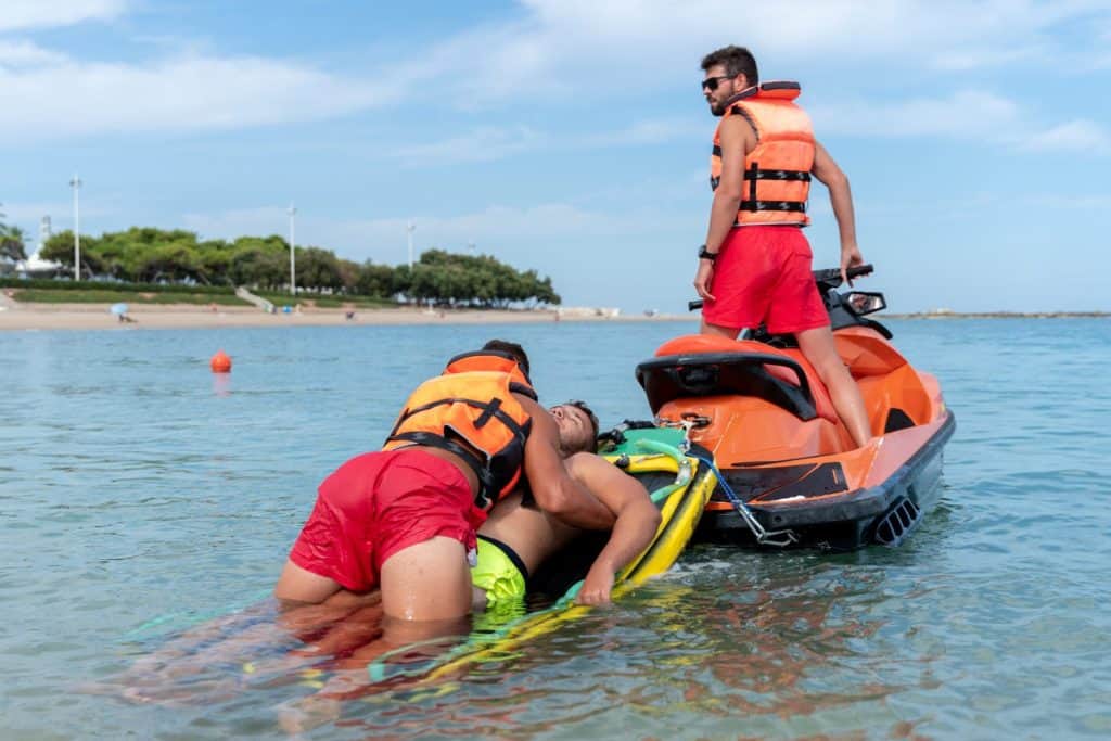 Photo with copy space of lifeguards rescue a man in the sea using a jet ski