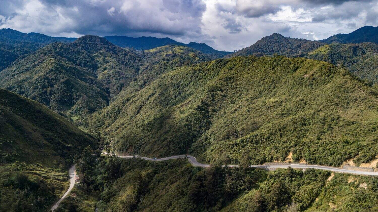 A mountain pass road on the side of a mountain in the PNG Highlands.