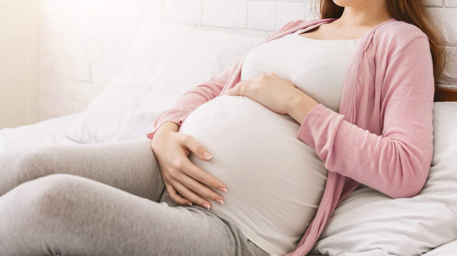 Pregnancy and rest. Young millennial pregnant woman lying in bed, panorama with free space
