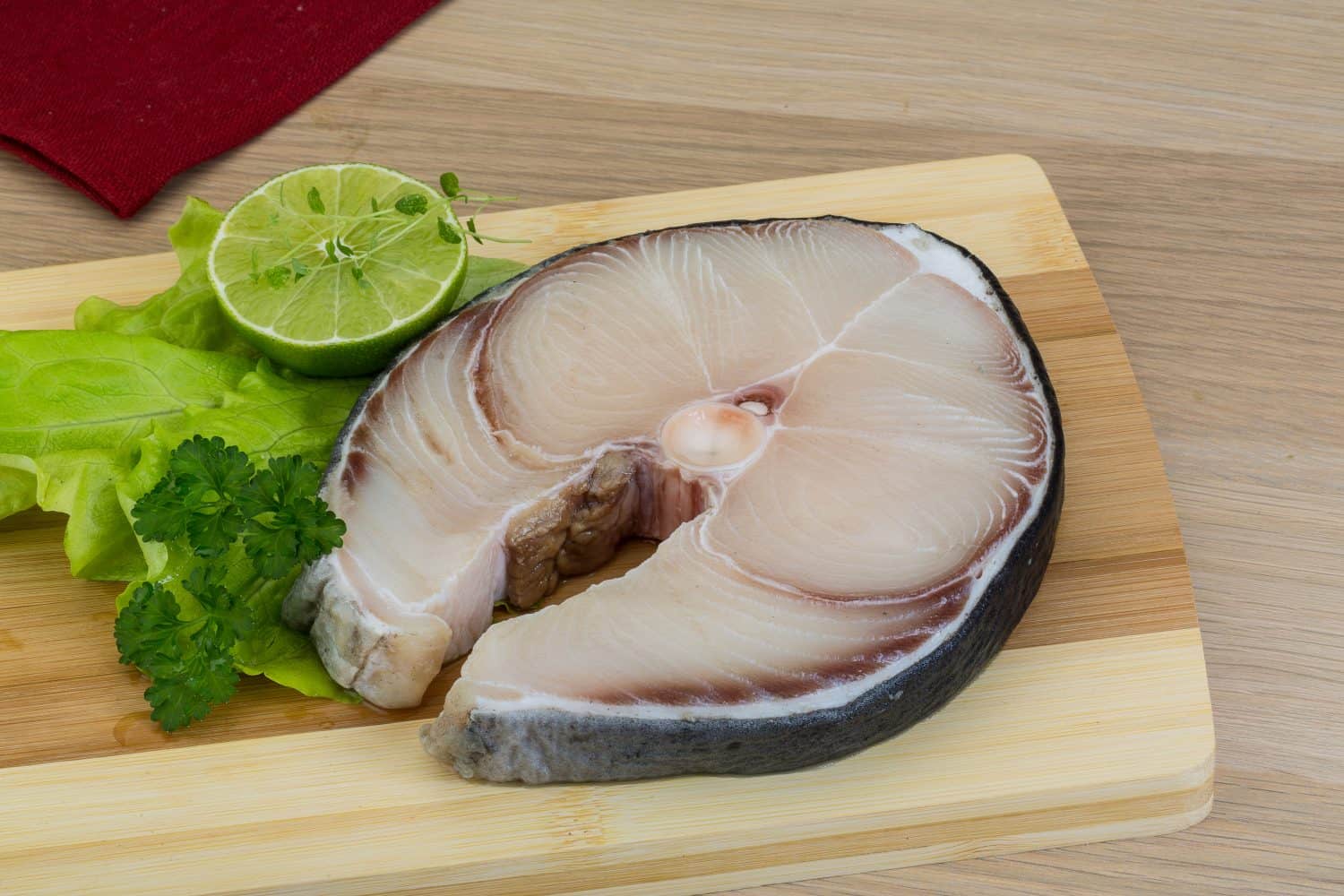 Raw blue shark steak with salad leaves and lime