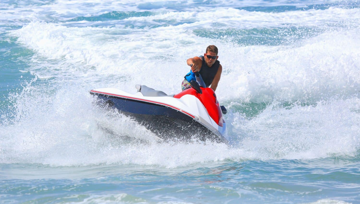 Young man of jet ski rider performs on the sea waves with much splashes -  Man on jet ski jump on the wave - Alanya, Turkey
