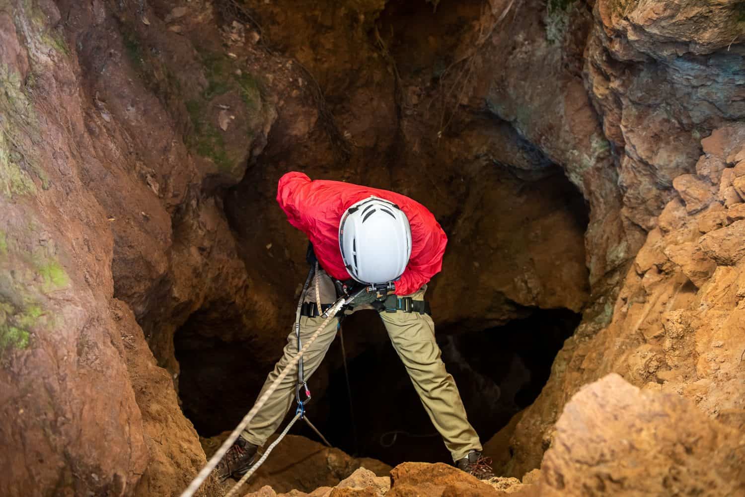 Rescuers or climber descends in a cave fast rope in the dark caves