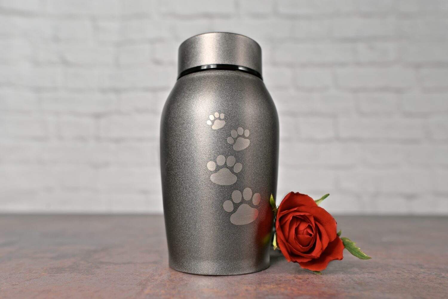 In remembrance of a pet. Pet urn beside a red rose.