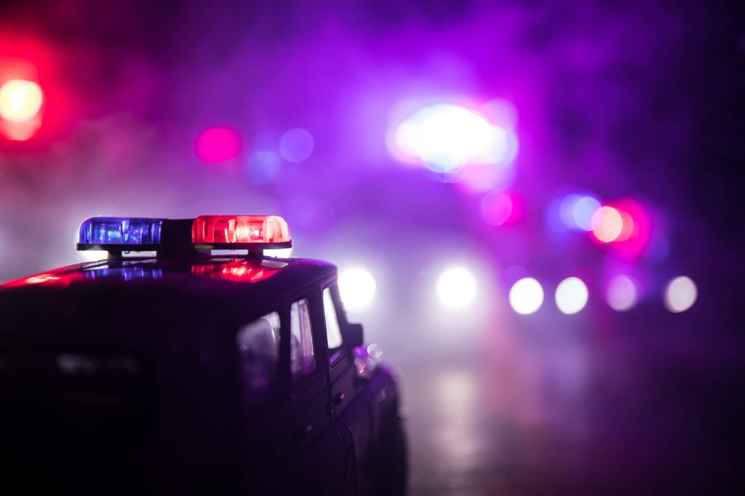 Police cars at night. Police car chasing a car at night with fog background. 911 Emergency response police car speeding to scene of crime. Selective focus
