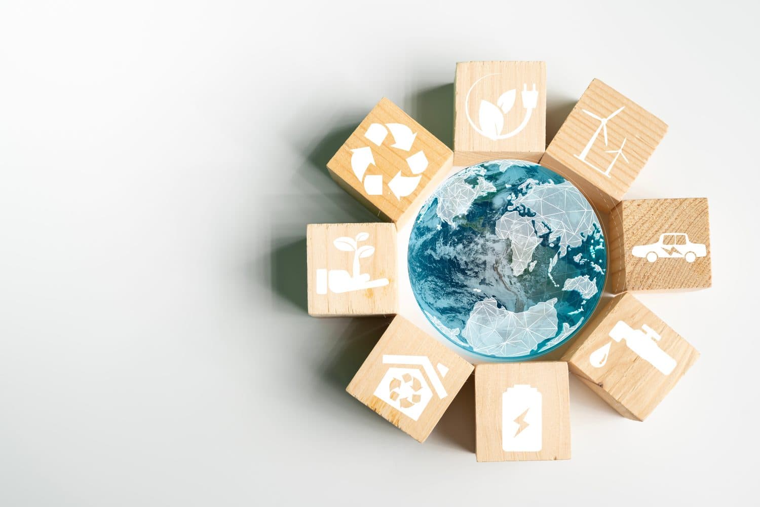 The globe is inside a glass globe surrounded by wooden blocks with eco-friendly campaign icons ,concept image of a campaign to reduce the amount of greenhouse gases accumulated in the earth's