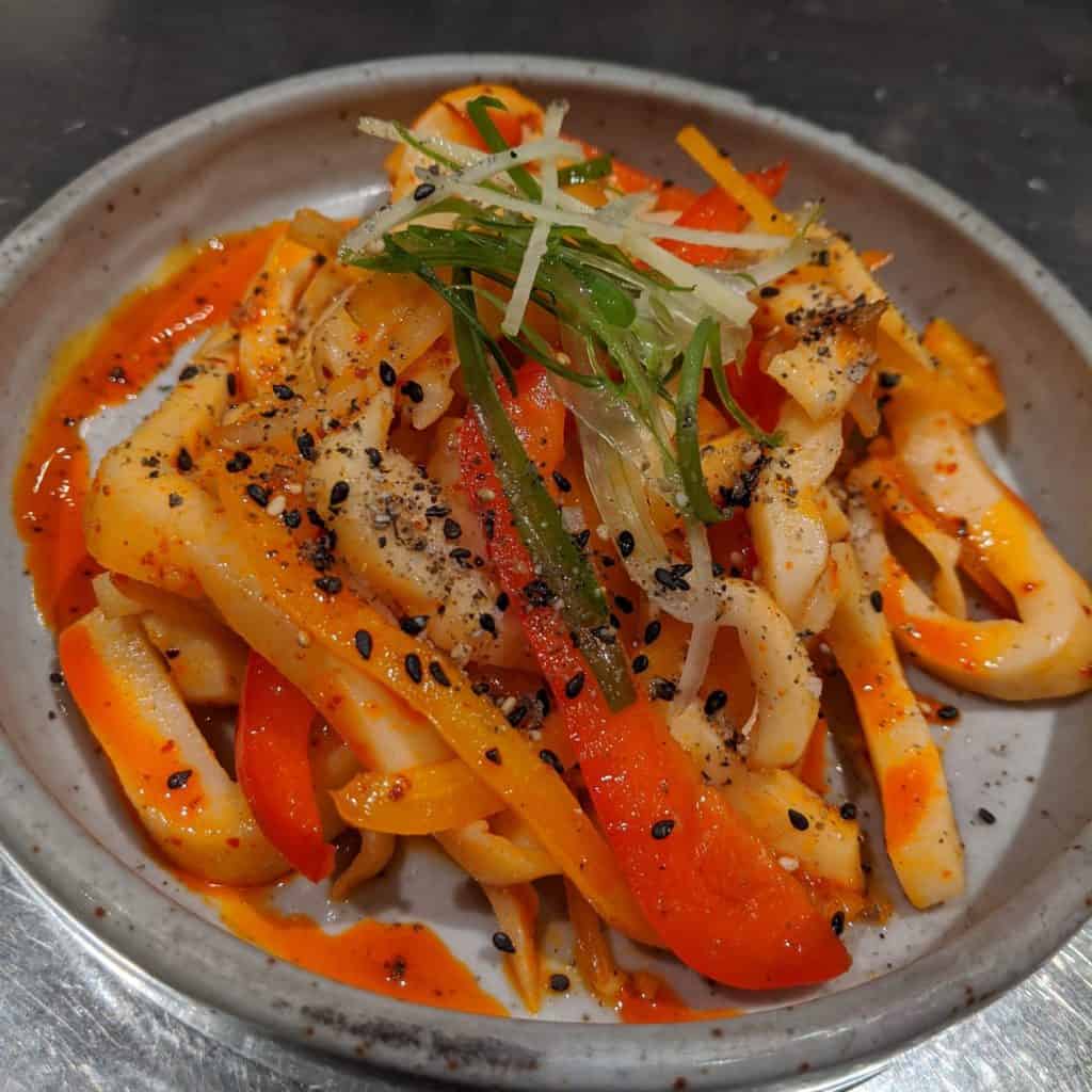 Sauteed Humboldt squid in chili oil with fresh green onion, sliced ginger, and sesame salt