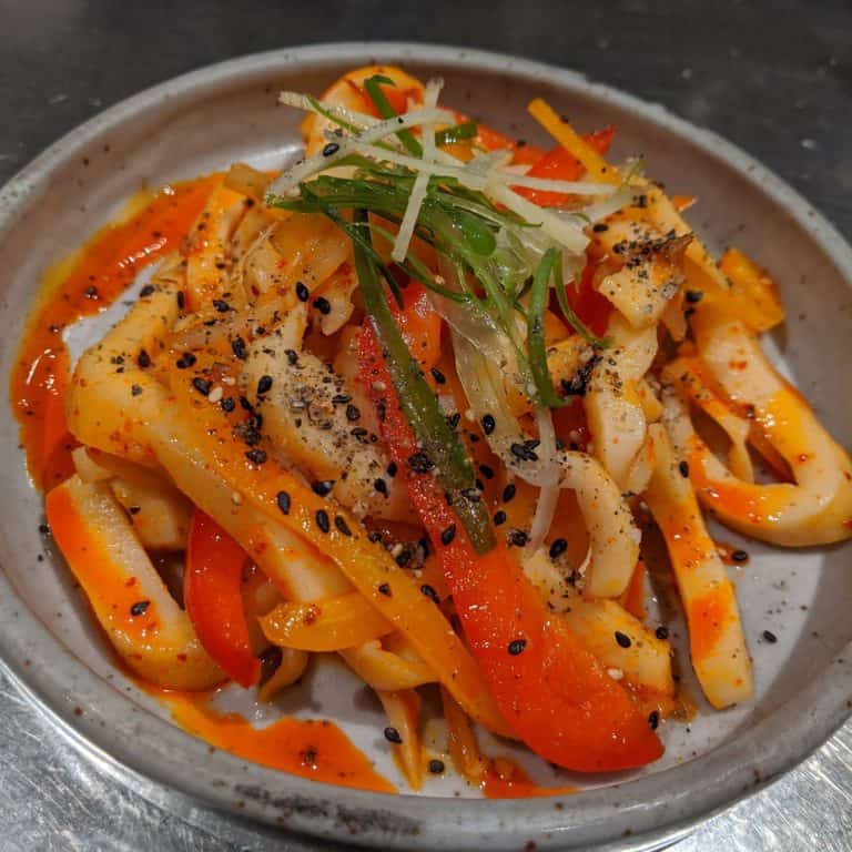 Sauteed Humboldt squid in chili oil with fresh green onion, sliced ginger, and sesame salt