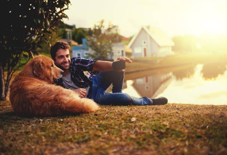 Just one more then we can head home. Full length shot of a handsome young man and his dog taking selfies by a lake in the park.