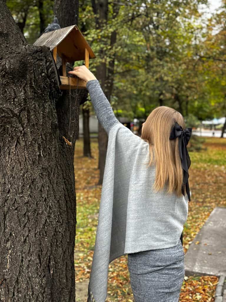 woman bird feeder in an autumn park