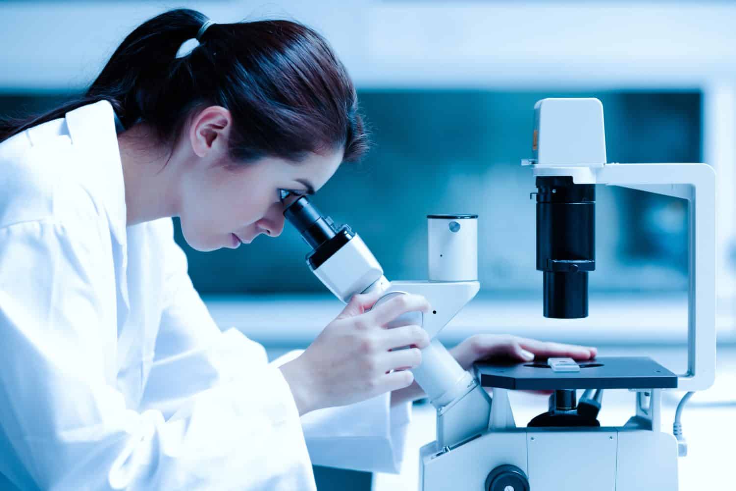 Scientist using a microscope in a laboratory, Testing for Coronavirus Covid19 vaccine