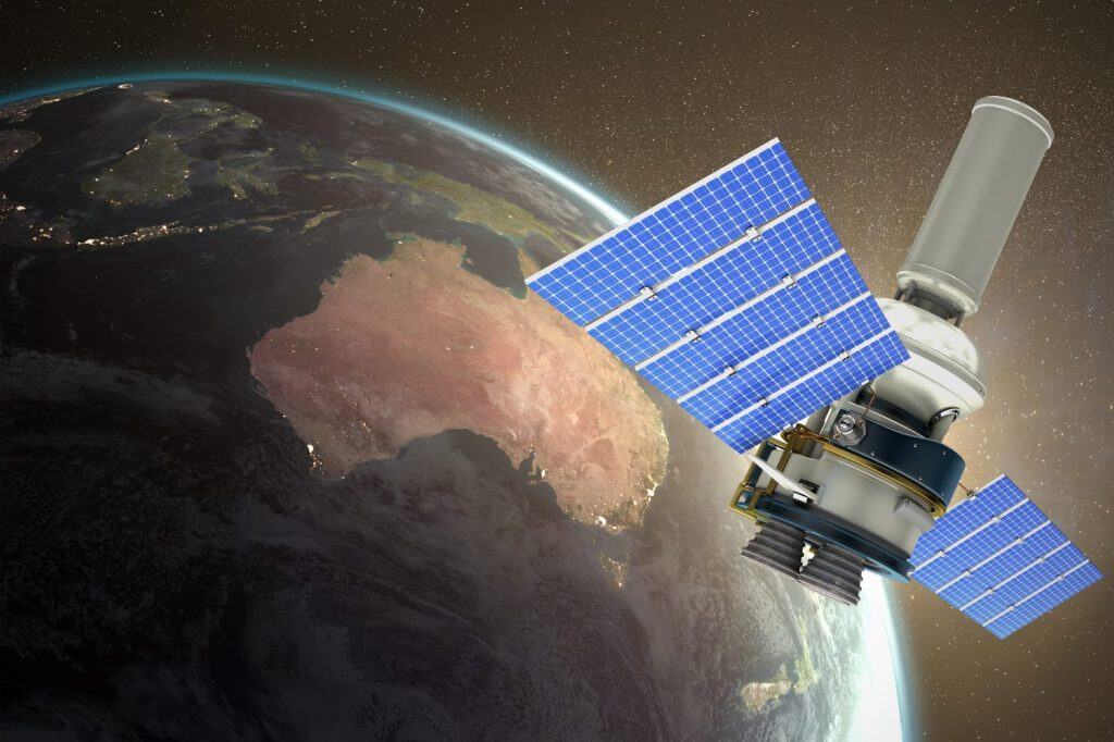 3d image of modern solar power satellite against white background against aerial view of the earth