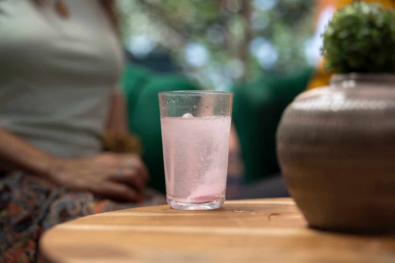 Elderly people drinking effervescent vitamins dissolved in water glasses, using for recovery and hydration. Senior couple taking supplements for wellness and longevity, health care. Close up.