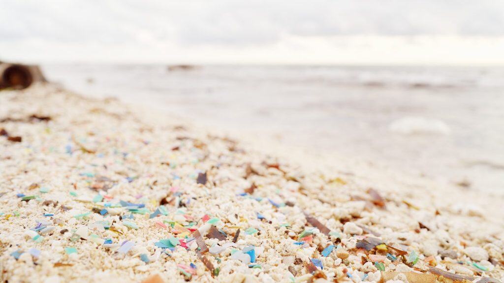 micro plastic particle pollution on beach, microplastic pieces in ocean water